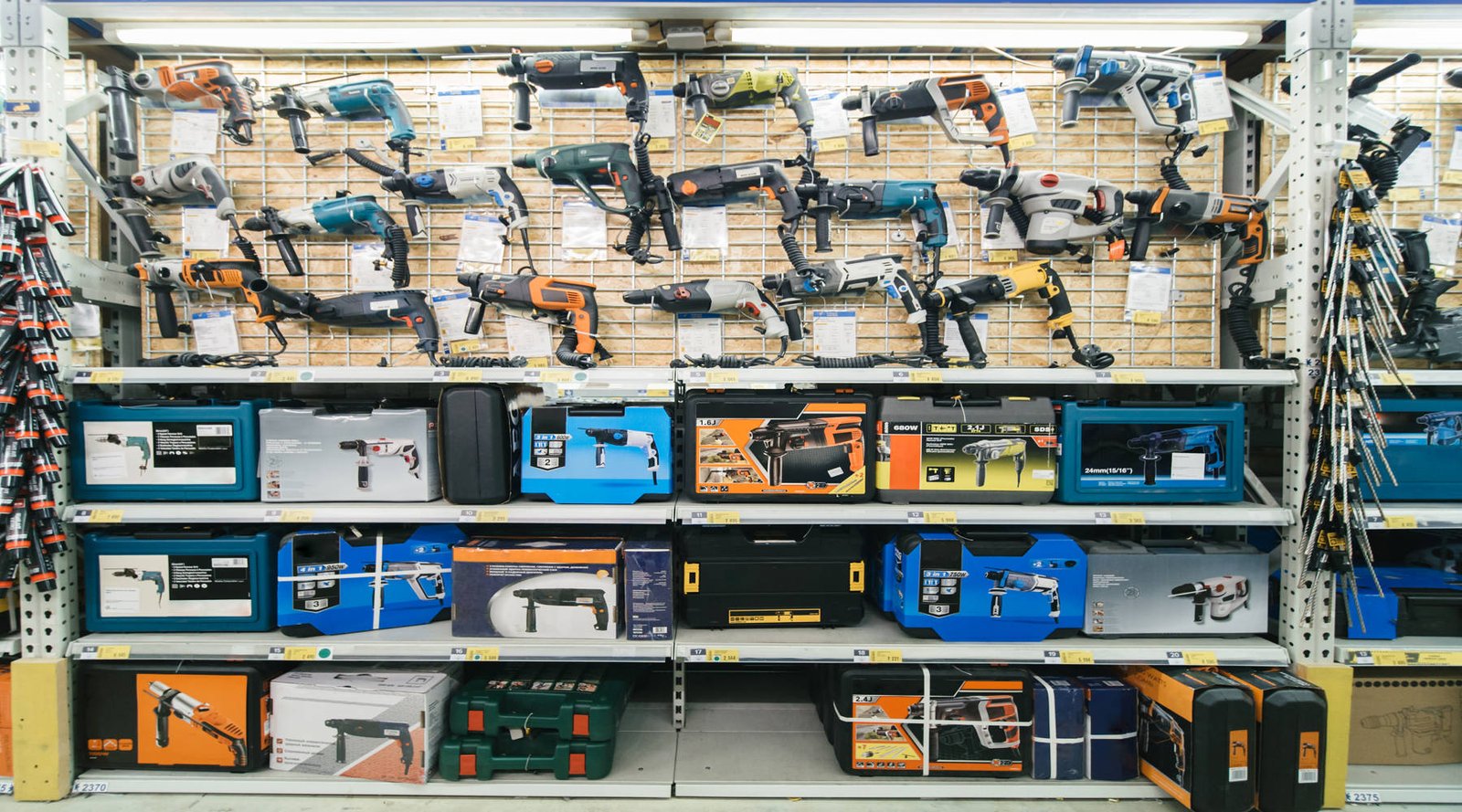 Contractor using a hammer drill machine to drill into a reinforced concrete wall inside a Dubai home