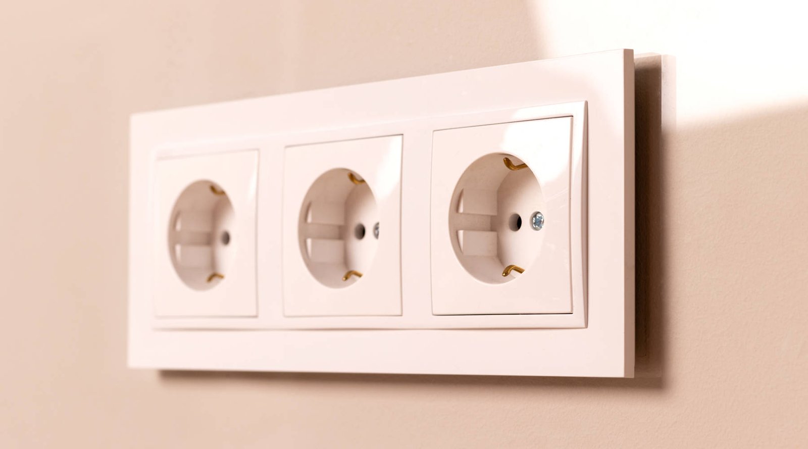 Modern white electrical switch and wall socket installed on interior wall in Dubai home